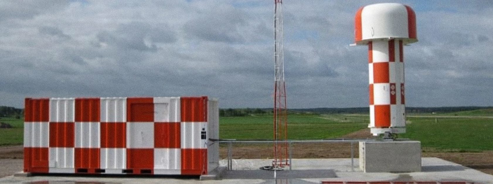 Precision approach radar tower and equipment shelter on a new concrete pad at the airfield.